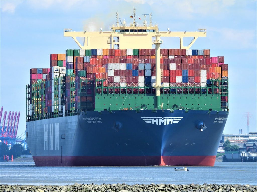 Front view of a massive cargo ship loaded with containers in Hamburgs harbor.